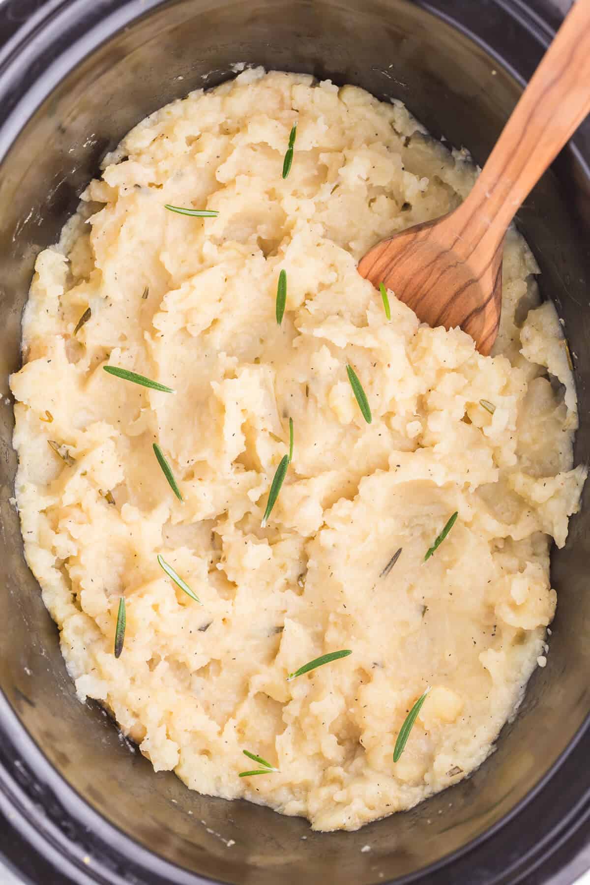 Slow Cooker Rosemary Garlic Mashed Potatoes - Make the creamiest mashed potatoes in your Crockpot! You'll love the rich, garlicky flavor in every bite for a delicious fall side dish.