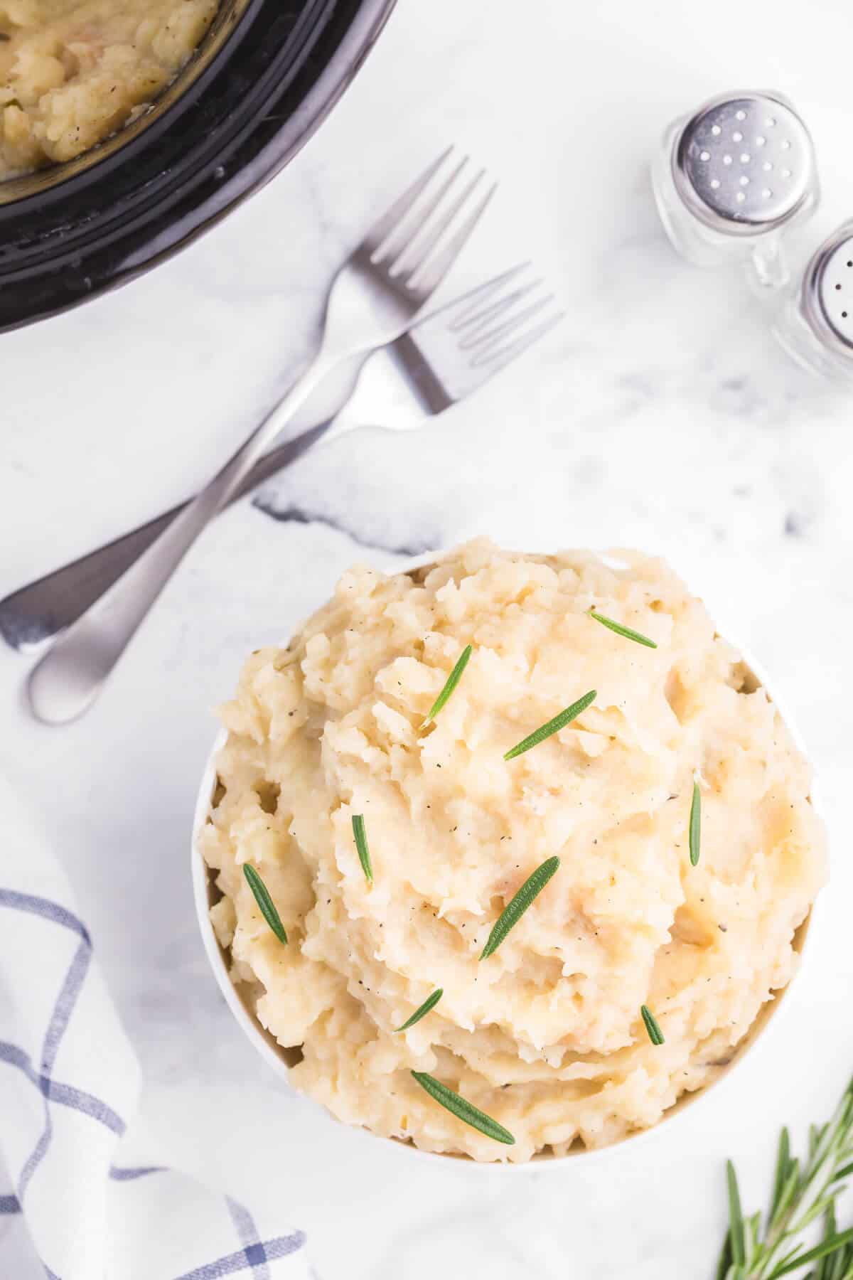 Slow Cooker Rosemary Garlic Mashed Potatoes - Make the creamiest mashed potatoes in your Crockpot! You'll love the rich, garlicky flavor in every bite for a delicious fall side dish.