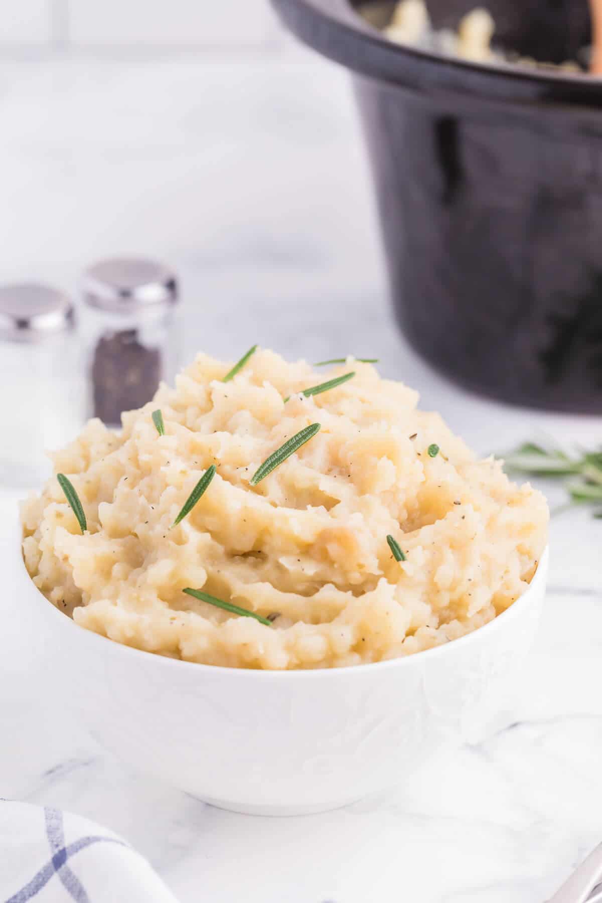 Slow Cooker Rosemary Garlic Mashed Potatoes - Make the creamiest mashed potatoes in your Crockpot! You'll love the rich, garlicky flavor in every bite for a delicious fall side dish.