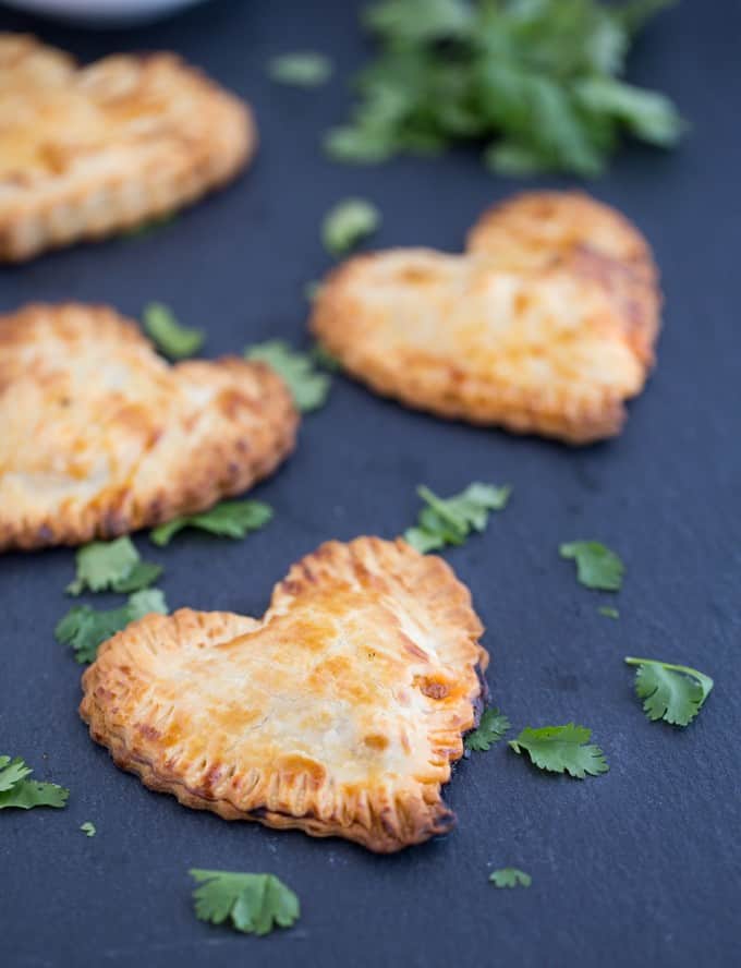 Butter Chicken Hand Pies - The best homemade Valentine's Day dinner ever! Make these heart pies with love and be done in 40 minutes flat. Creamy, flavourful Butter Chicken is stuffed inside a golden, flaky heart shaped crust!