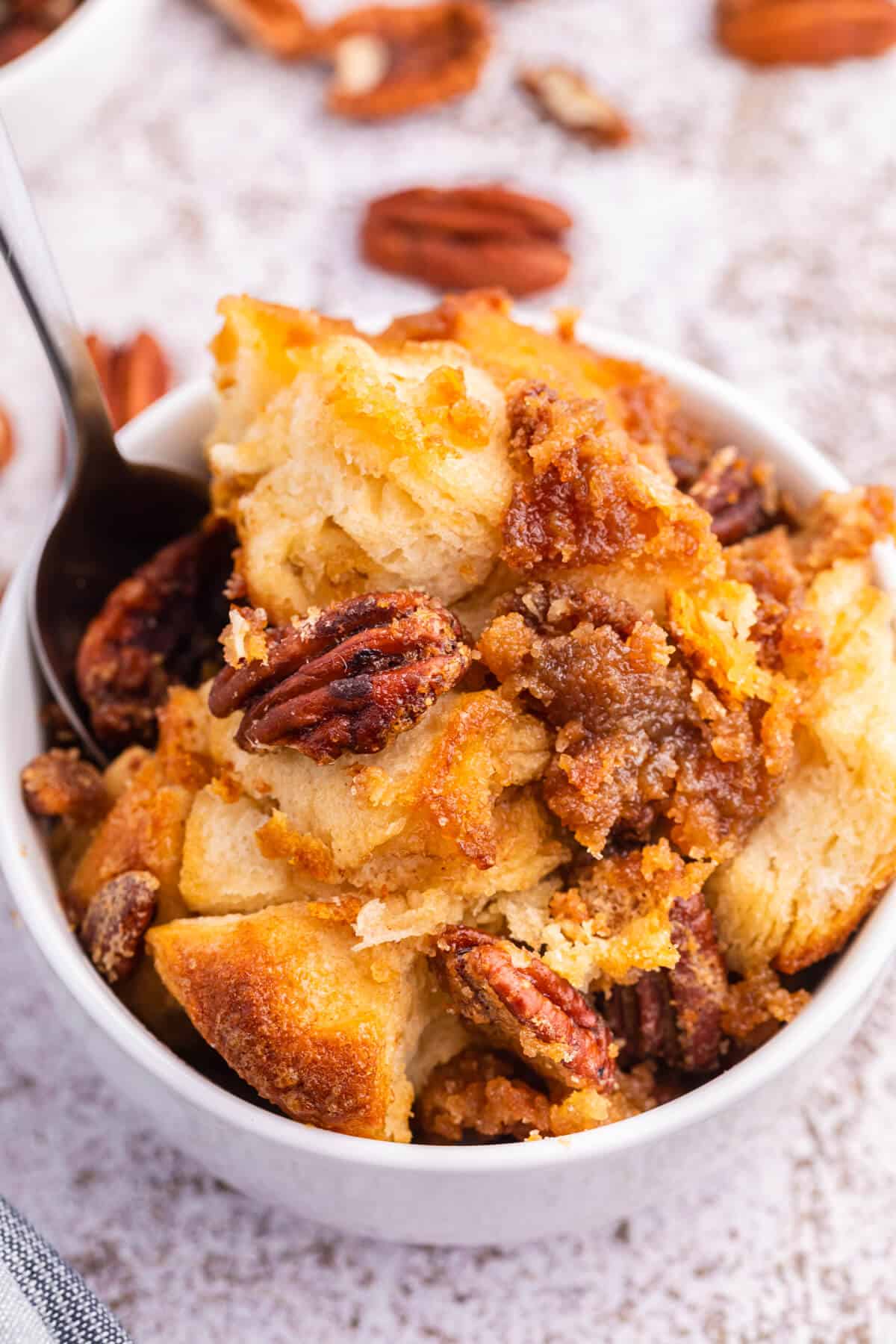 Pecan butter tart buns in a bowl with a spoon.