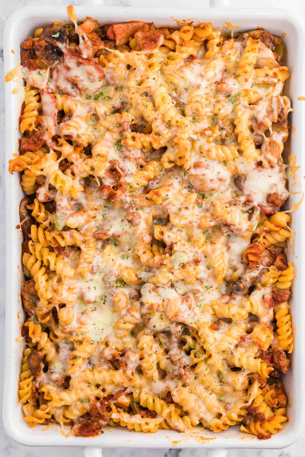 Meatzza Casserole - This crowd pleasing casserole recipe is packed with four kinds of meat, pizza sauce, veggies and oohey gooey cheese!