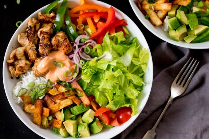 A tex mex lunch bowl on a dark surface.