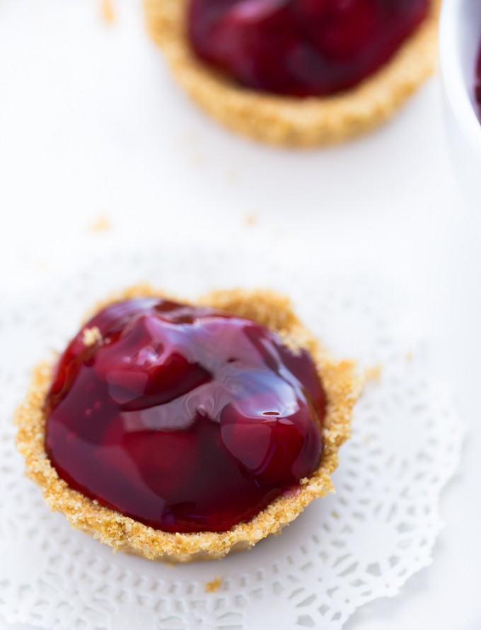No-Bake Cherry Tarts - Made with a graham cracker crumb crust and stuffed with cherry pie filling. You won't be able to get enough of this easy, no-bake dessert!