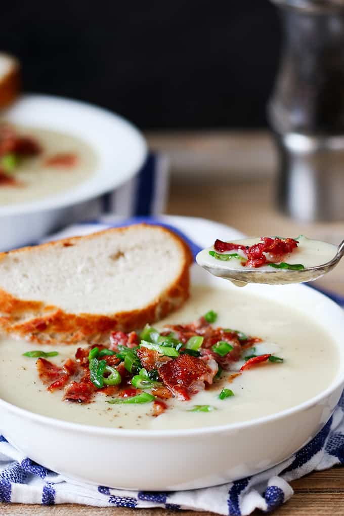 Cauliflower Soup with bacon and a spoon with soup on it.
