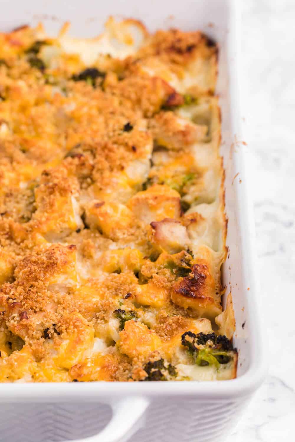 Chicken broccoli biscuit bake in a white casserole dish.