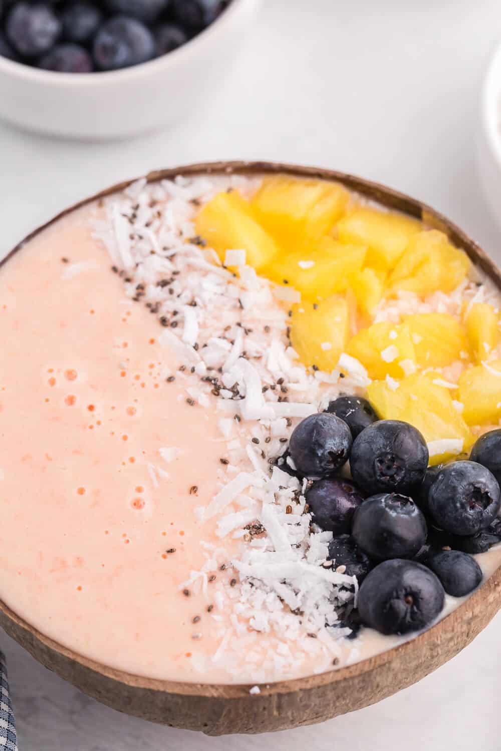 Grapefruit Smoothie Bowl - This easy smoothie bowl recipe is healthy and naturally sweet way to kickstart your mornings. It's made with creamy blend of Sweet Scarletts Texas Red Grapefruit, Greek Yogurt, pineapple and a banana. Top it with some fresh blueberries, seeds and coconut. Yum!