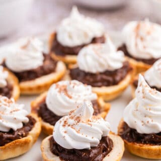 A plate of chocolate cream tarts.