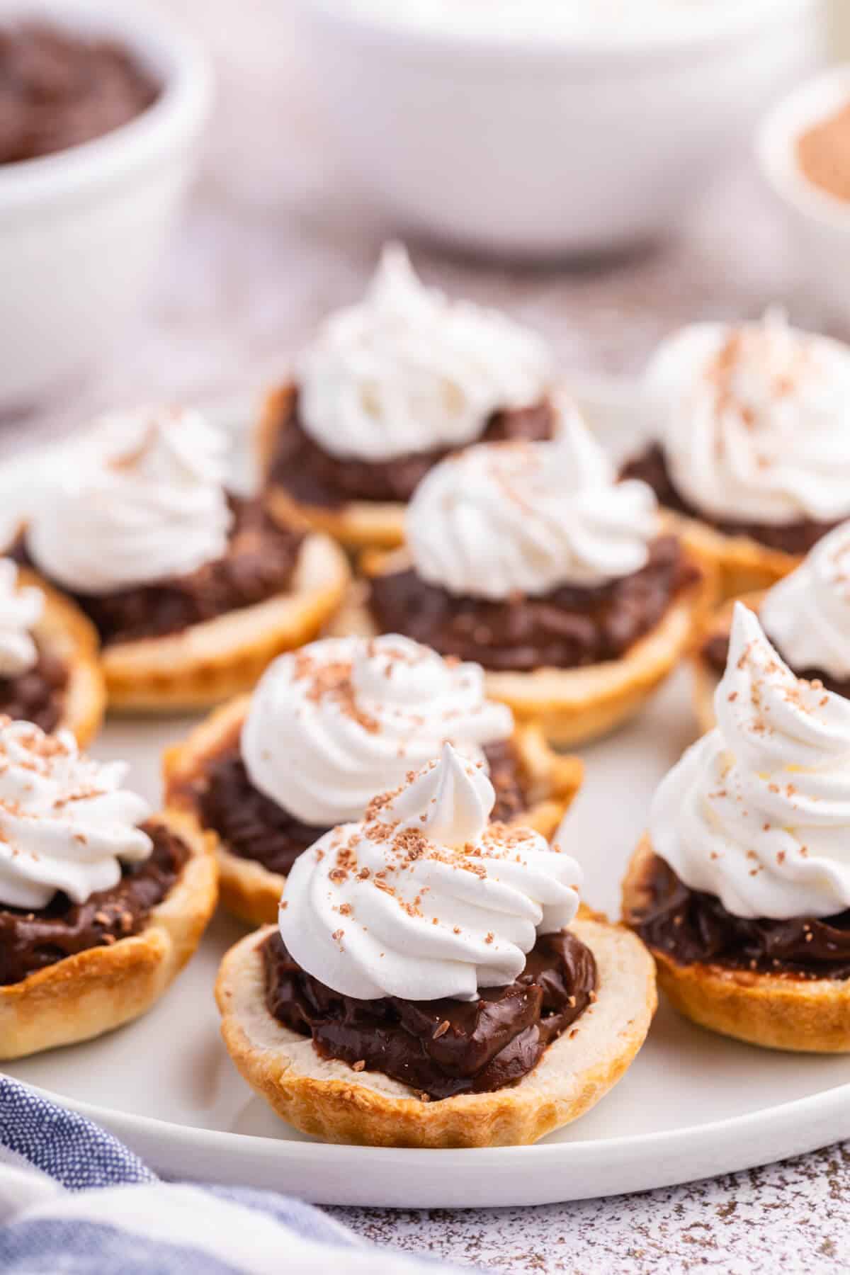 A plate of chocolate cream tarts.