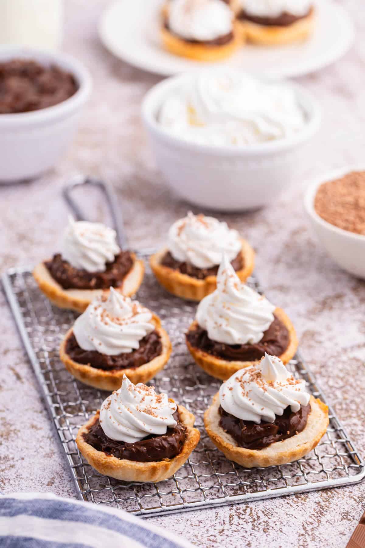 Chocolate cream tarts on a rack.