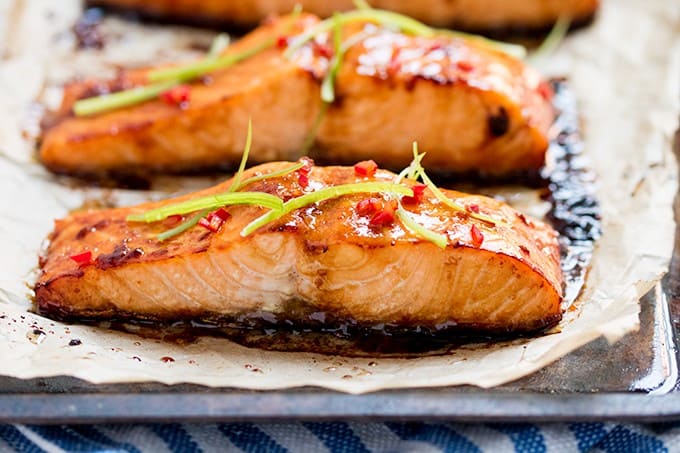 Honey Garlic Baked Salmon - This Asian-inspires salmon dish is as healthy as it is delicious! The simple sesame oil, soy sauce, and honey marinade makes even fish haters love this main dish.