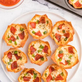 Pizza Wonton Cups Recipe - East meets West in this simple crunchy appetizer. A crispy wonton is filled with cheesy pizza goodness with any toppings you want!