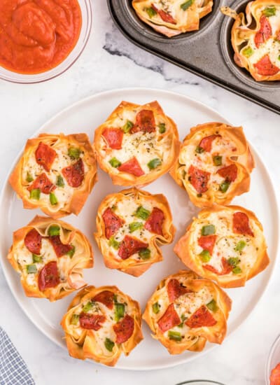 Pizza Wonton Cups Recipe - East meets West in this simple crunchy appetizer. A crispy wonton is filled with cheesy pizza goodness with any toppings you want!