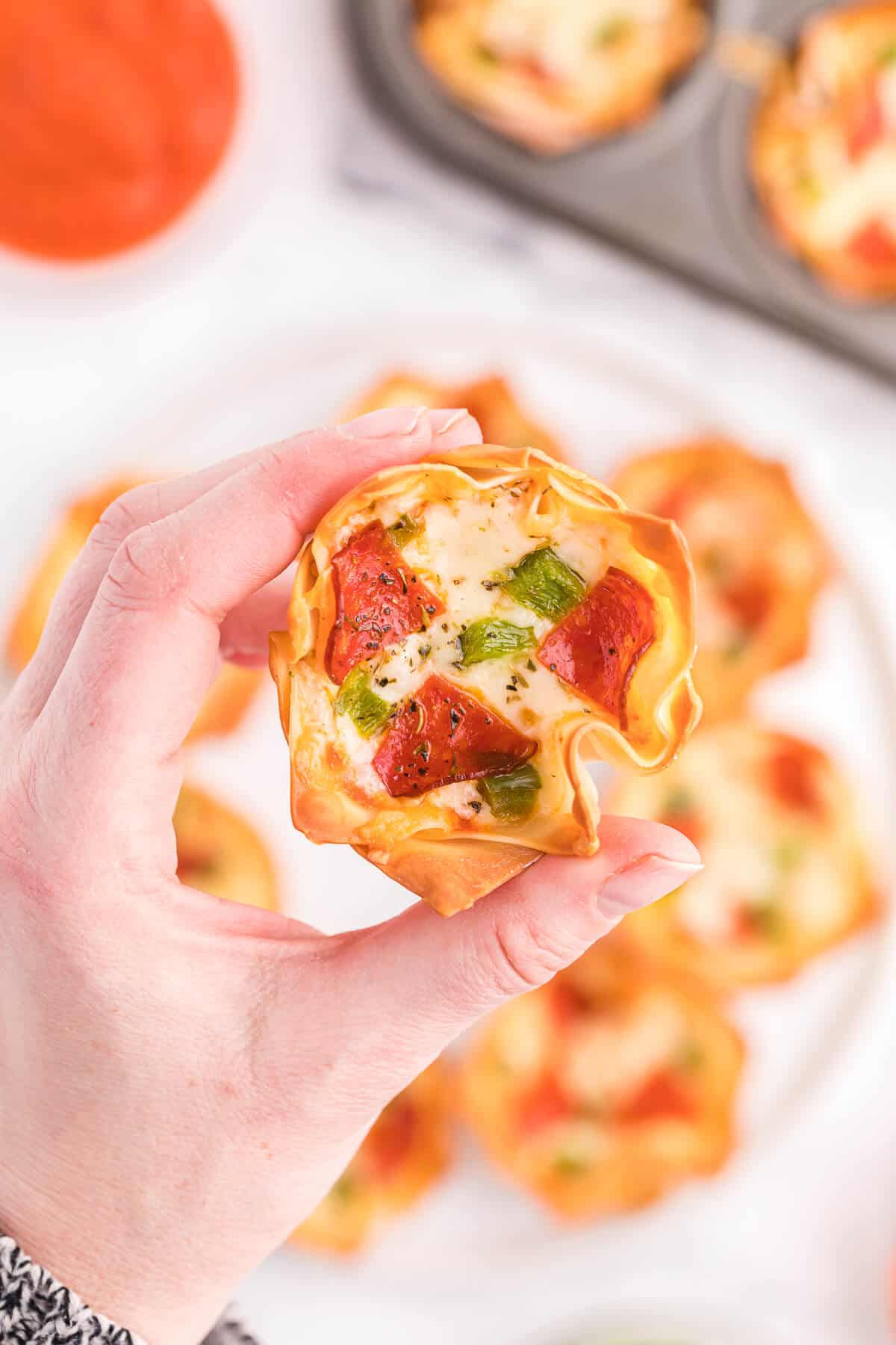 Pizza Wonton Cups Recipe - East meets West in this simple crunchy appetizer. A crispy wonton is filled with cheesy pizza goodness with any toppings you want!