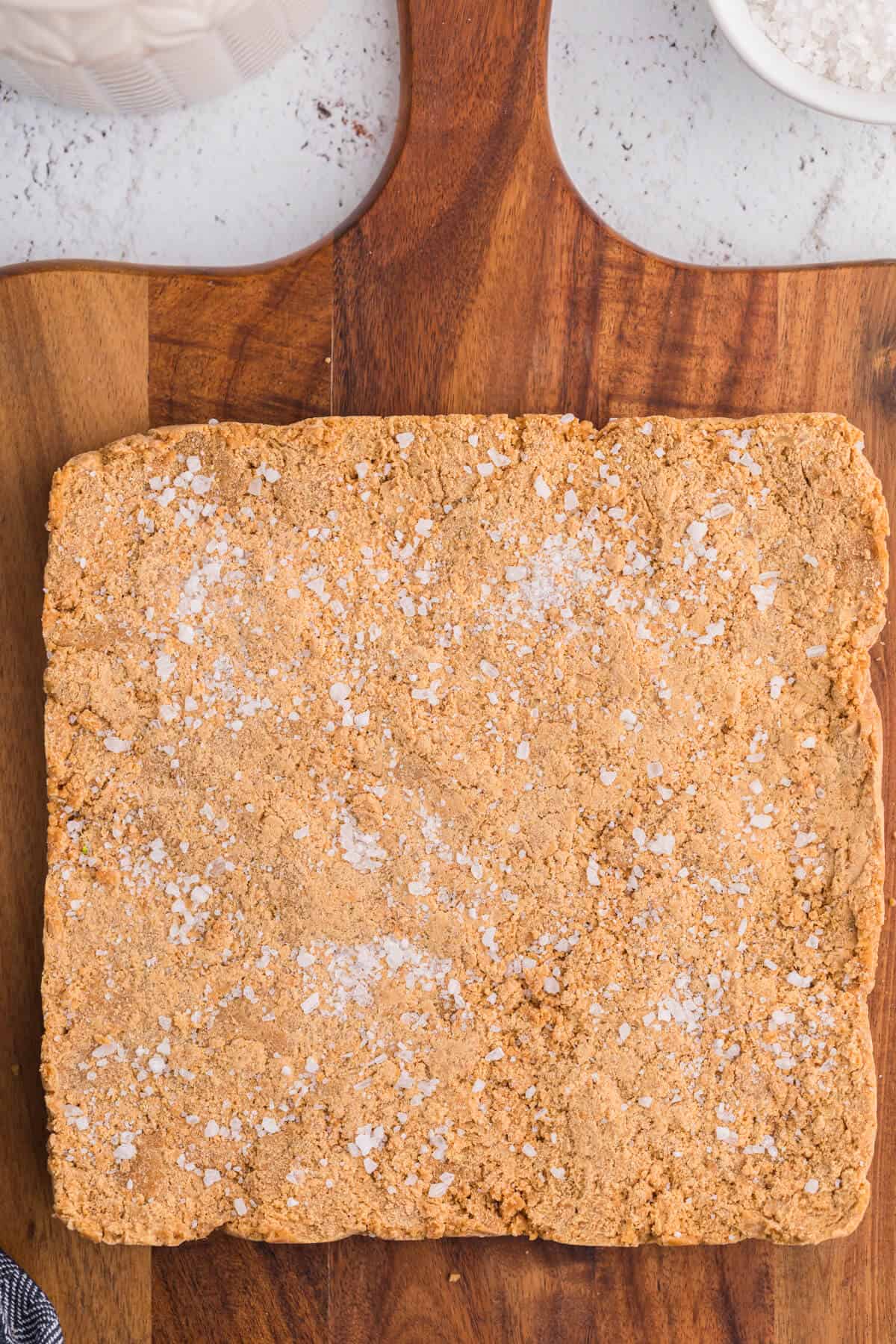 Salted caramel fudge on a wooden cutting board.