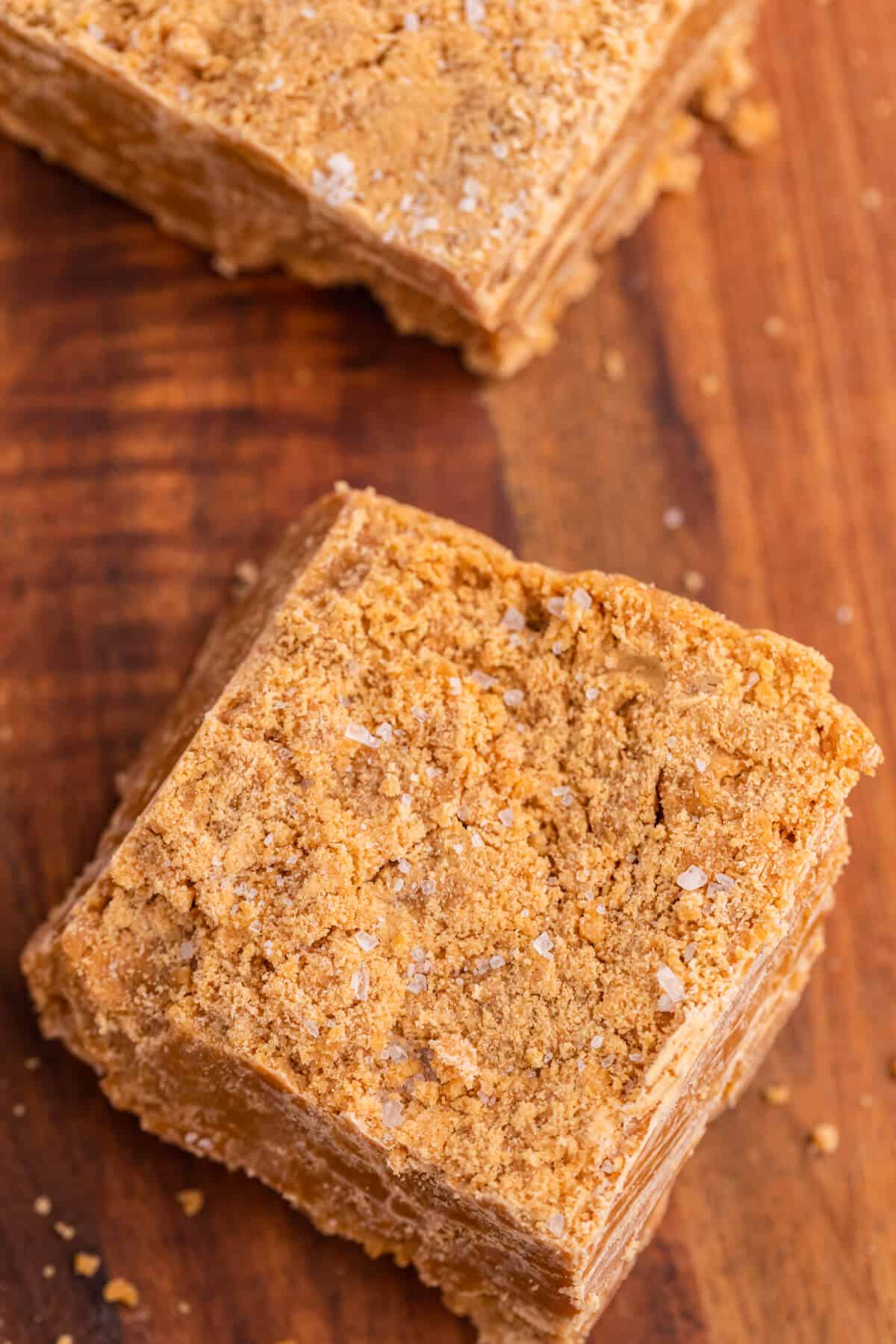 Salted caramel fudge square on a wooden cutting board.