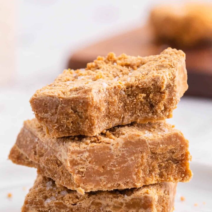 A stack of three salted caramel fudge bars with a bite out of the top bar.