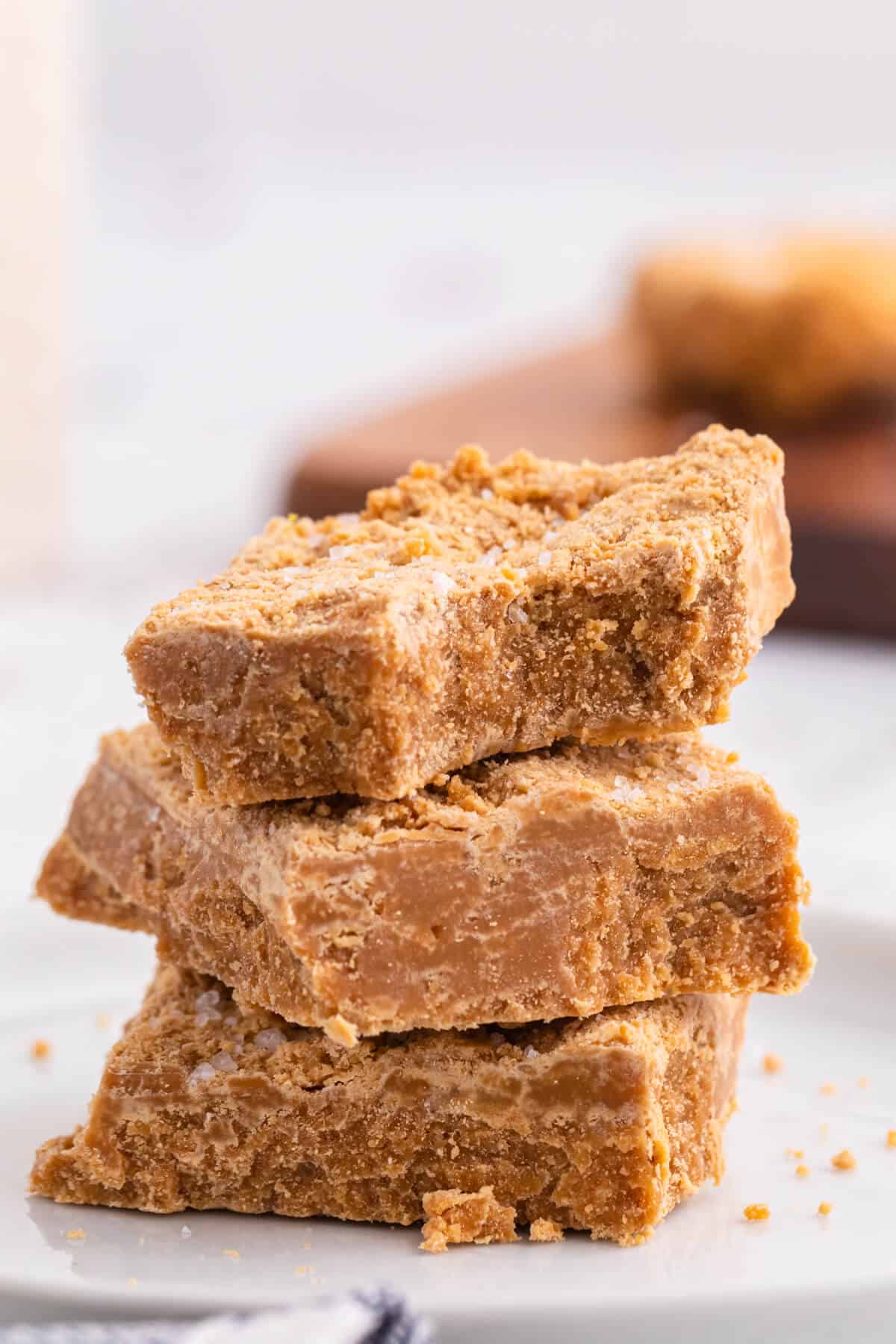 A stack of three salted caramel fudge bars with a bite out of the top bar.