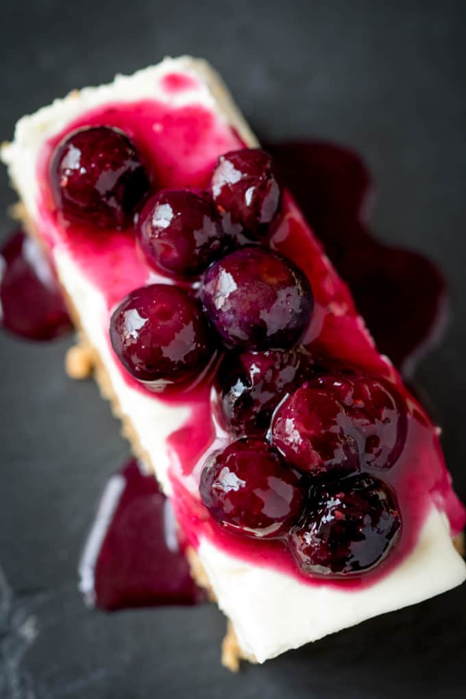 Blueberry lemon cheesecake bar on a black surface.