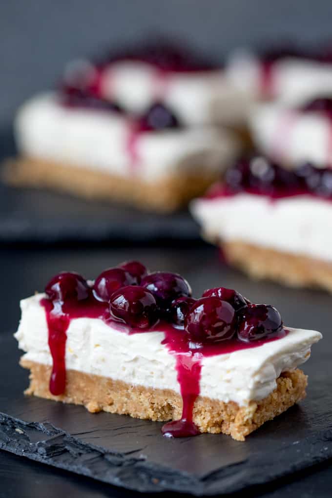 Blueberry lemon cheesecake bar on a black surface.