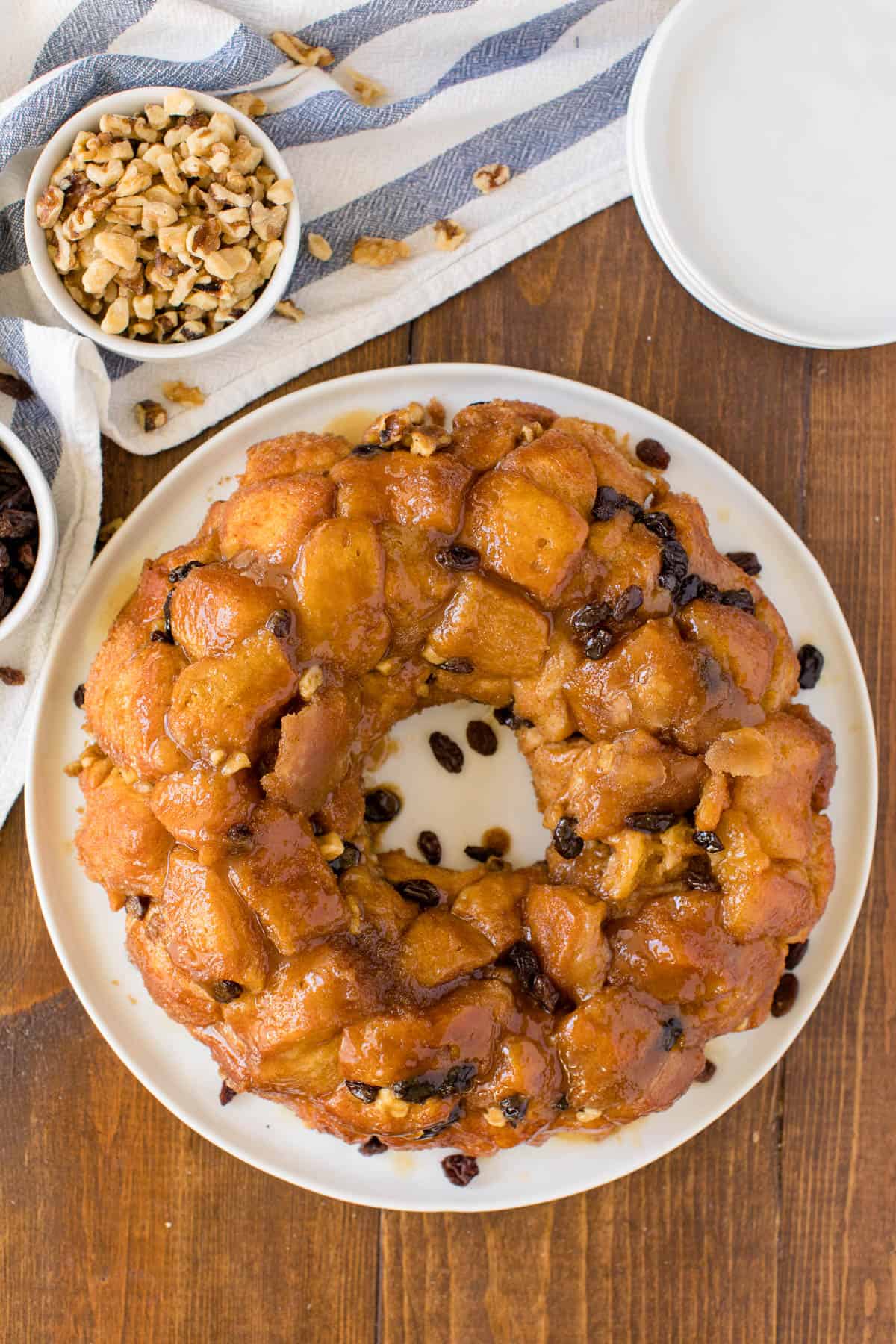 Classic monkey bread on a plate on a wooden table with ingredients and linens.