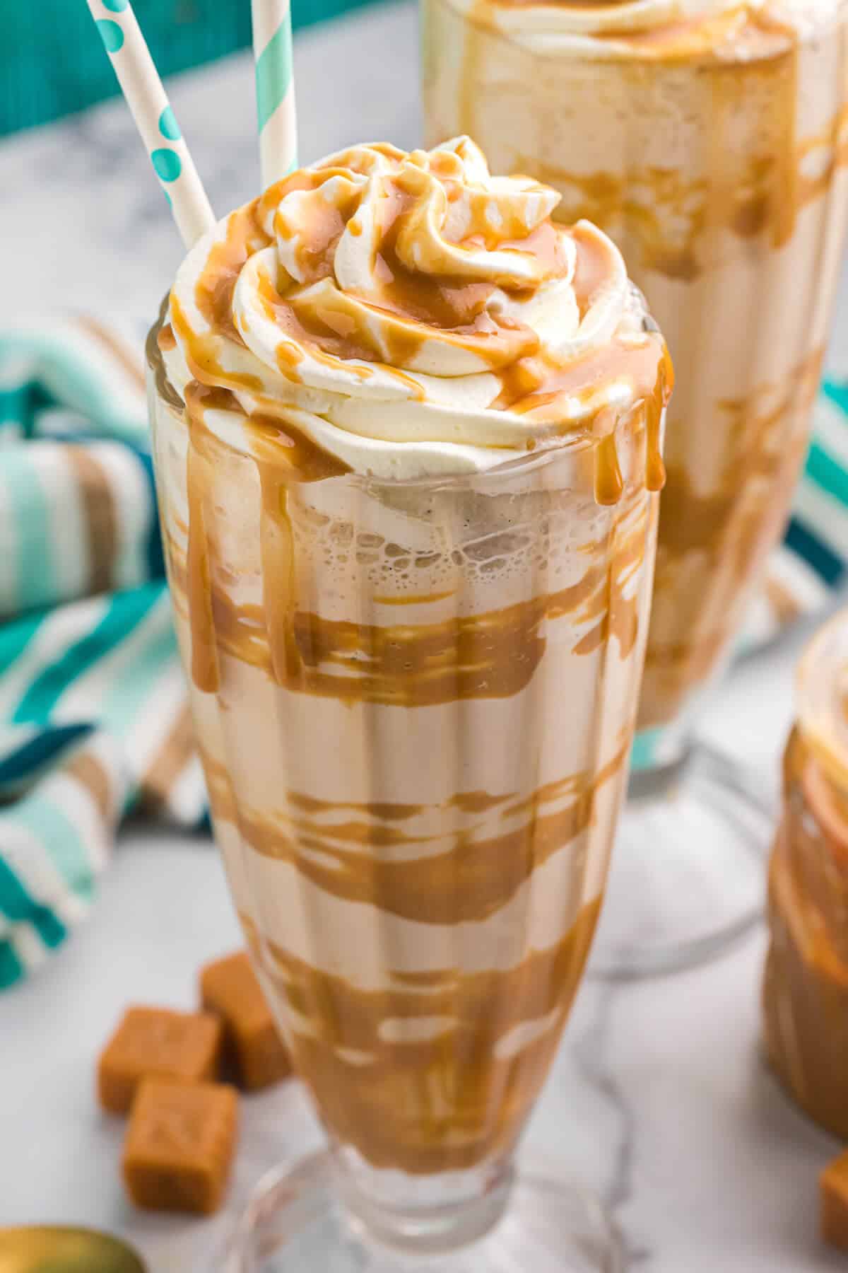 A dulce de leche coffee milkshake with a straw.