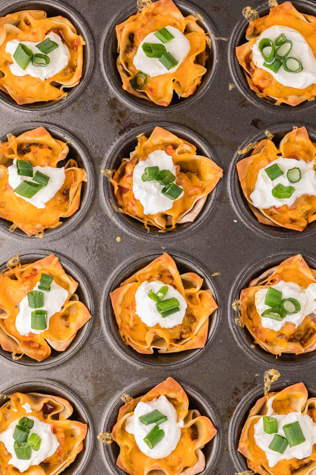 Taco Wonton Cups - Make this yummy appetizer in a muffin tin with wonton wrappers! Top the seasoned taco beef with your favourite fresh toppings and melted cheese and watch these crispy treats disappear in a flash.