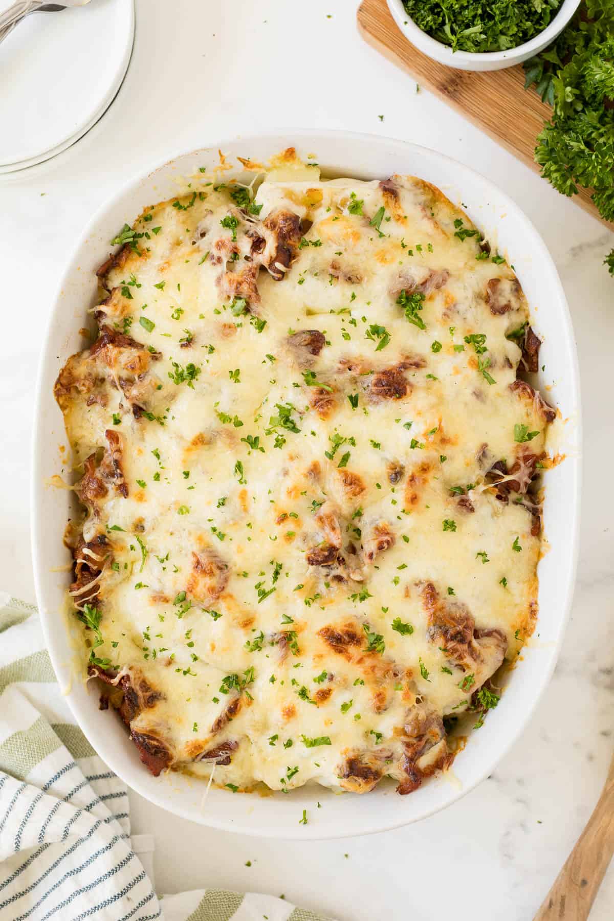 Bacon ranch potatoes in a white casserole dish.