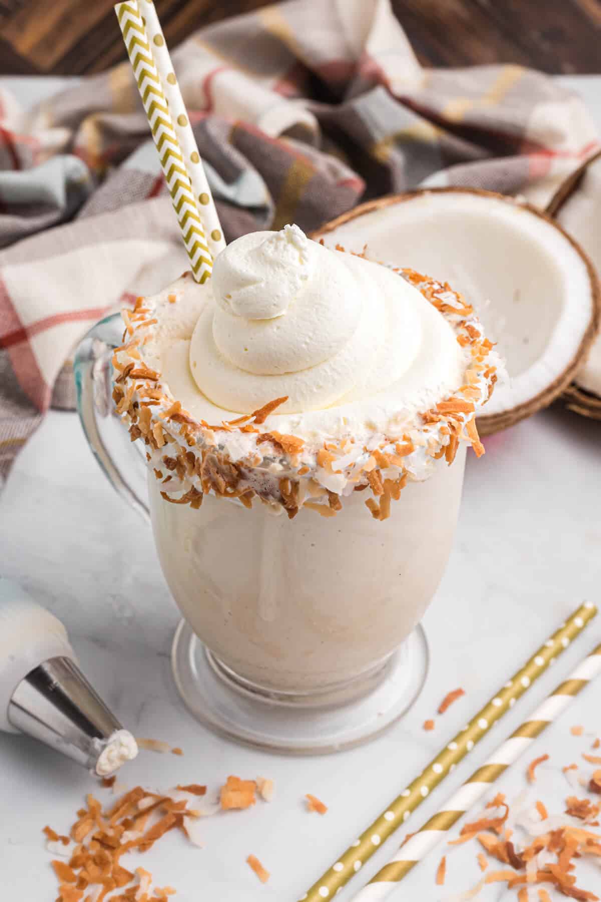 Coconut coffee milkshake with a straw.