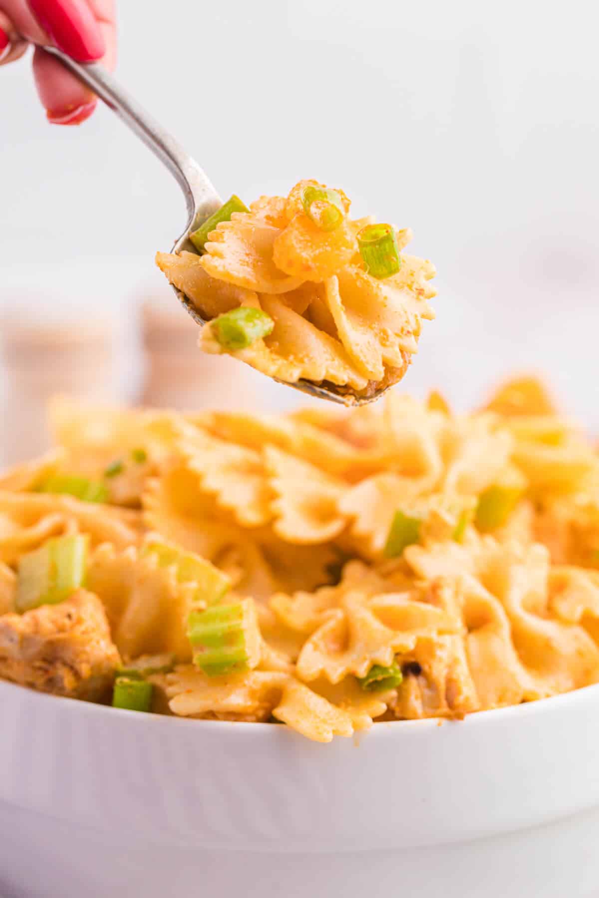 A spoon of creamy curried chicken pasta salad.