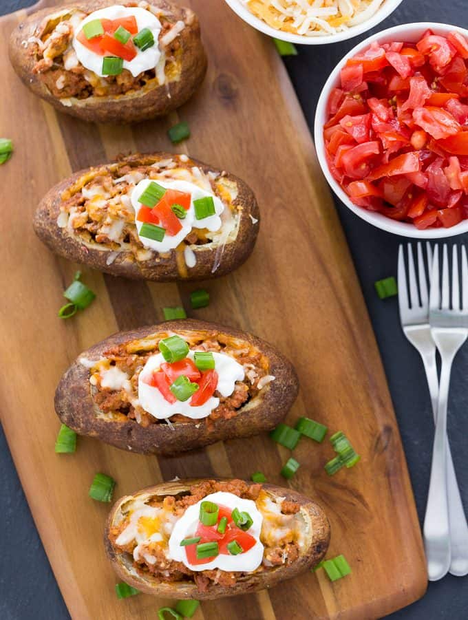 Chicken Taco Twice-Baked Potatoes - Switch it up this Taco Tuesday! Put all your favorite chicken taco toppings in a loaded baked potato for the ultimate comfort food recipe.
