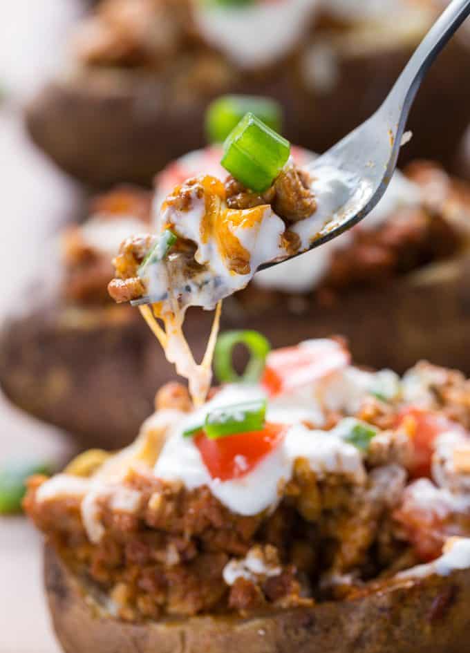Chicken Taco Twice-Baked Potatoes - Switch it up this Taco Tuesday! Put all your favorite chicken taco toppings in a loaded baked potato for the ultimate comfort food recipe.