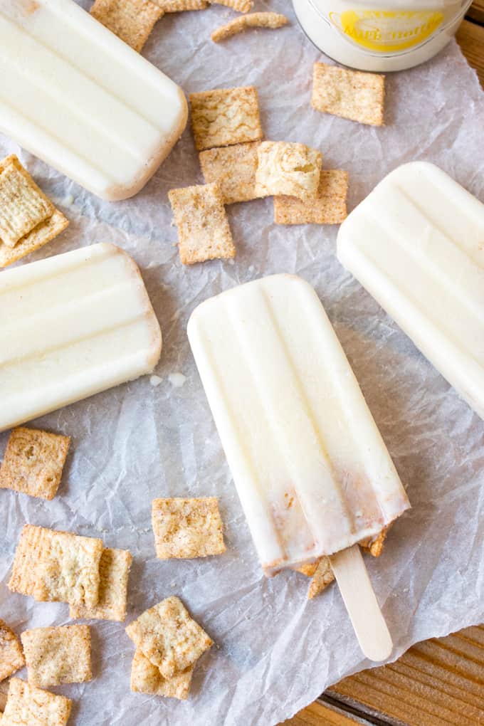 Cereal milk popsicles laying flat on parchment paper.