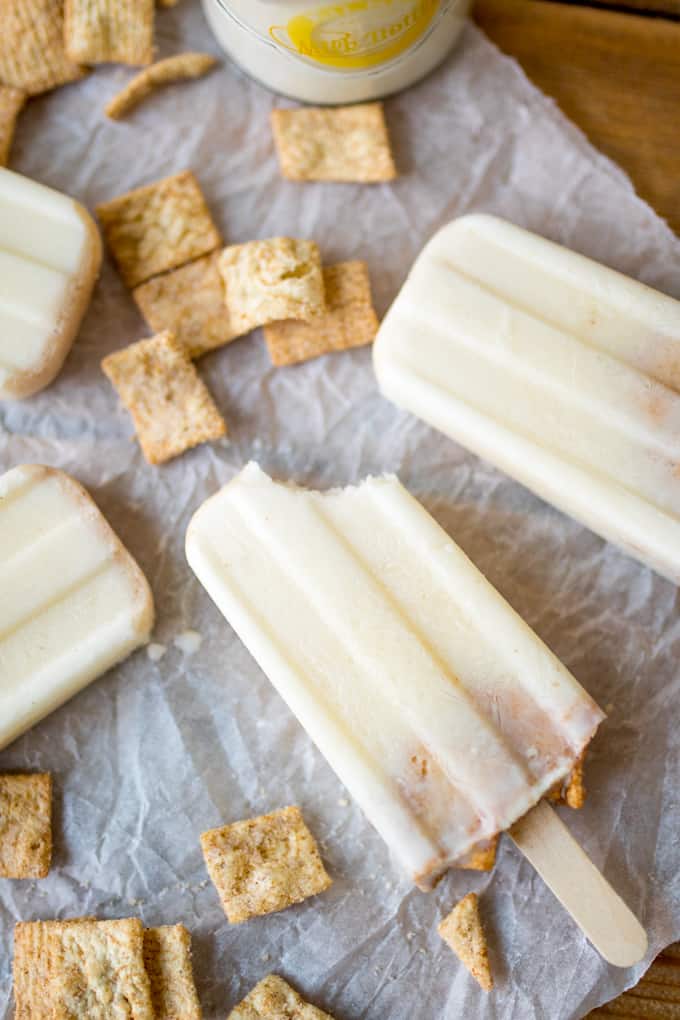 Cereal milk popsicles laying flat with a bite out of one.