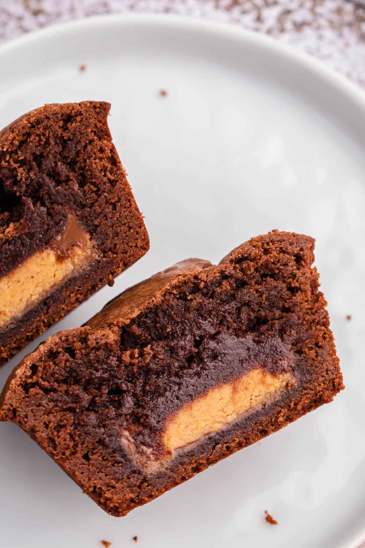 Reese's stuffed brownies cut in half on a plate.