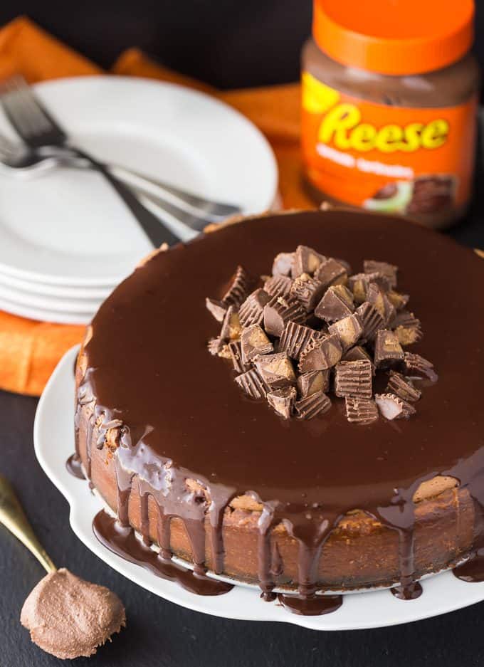 Reese Cheesecake - A chocolate and peanut butter dream! This decadent cheesecake is sandwiched by chocolate crust and chocolate ganache with a peanut butter punch.