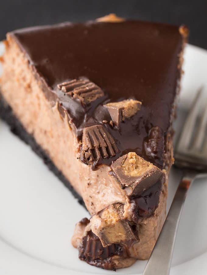 Reese Cheesecake - A chocolate and peanut butter dream! This decadent cheesecake is sandwiched by chocolate crust and chocolate ganache with a peanut butter punch.