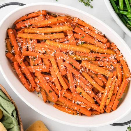 Parmesan roasted carrots in a white casserole dish.
