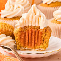A cupcake sliced in half on a plate.