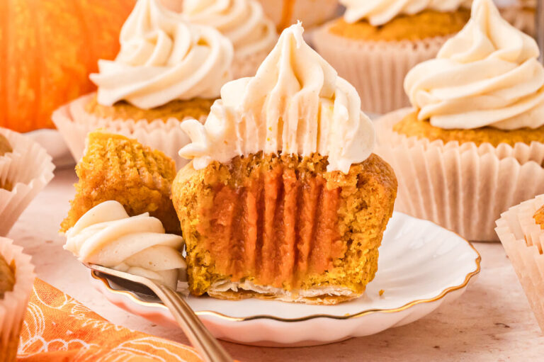 A cupcake sliced in half on a plate.