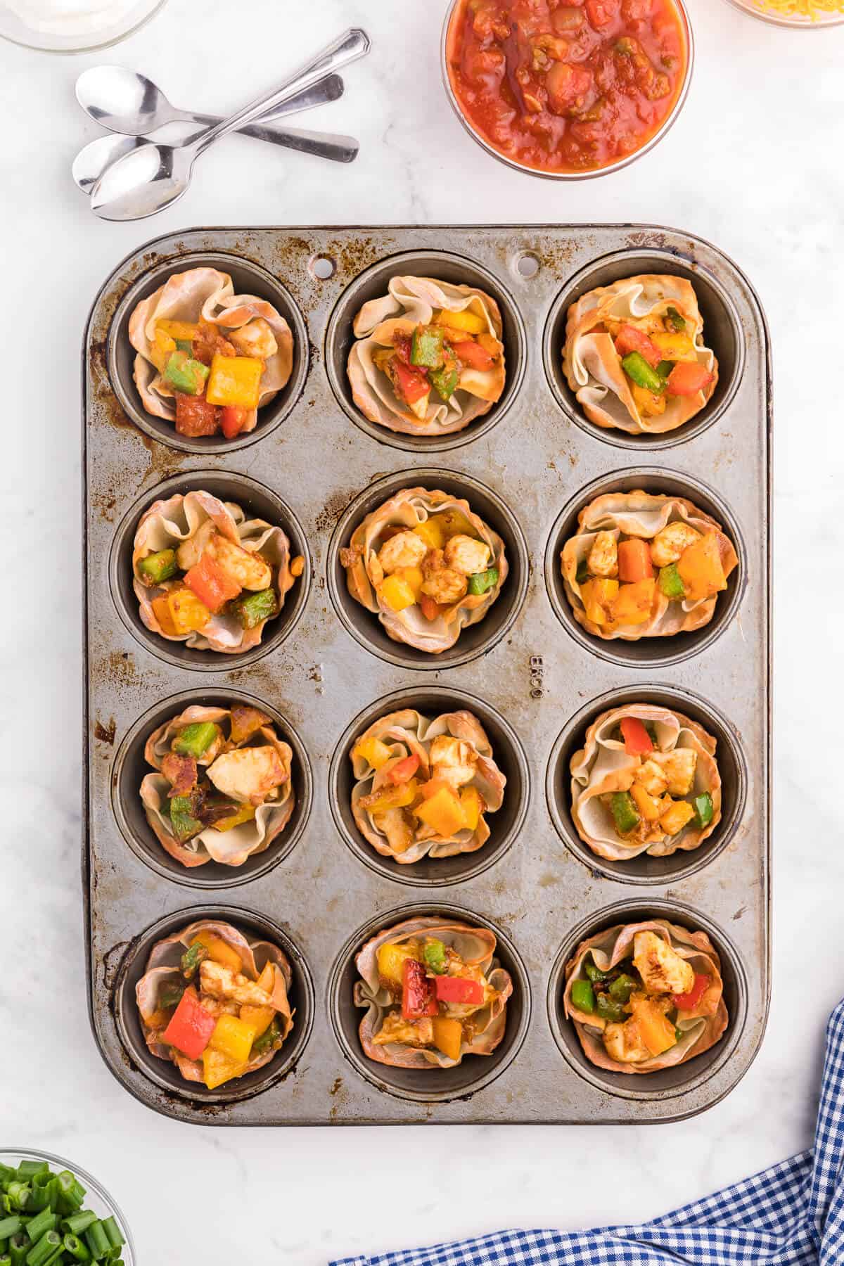 Chicken Fajita Wonton Cups - A little East, a little West. These appetizer cups are perfect for entertaining with a festive Mexican filling in a crunchy wonton.