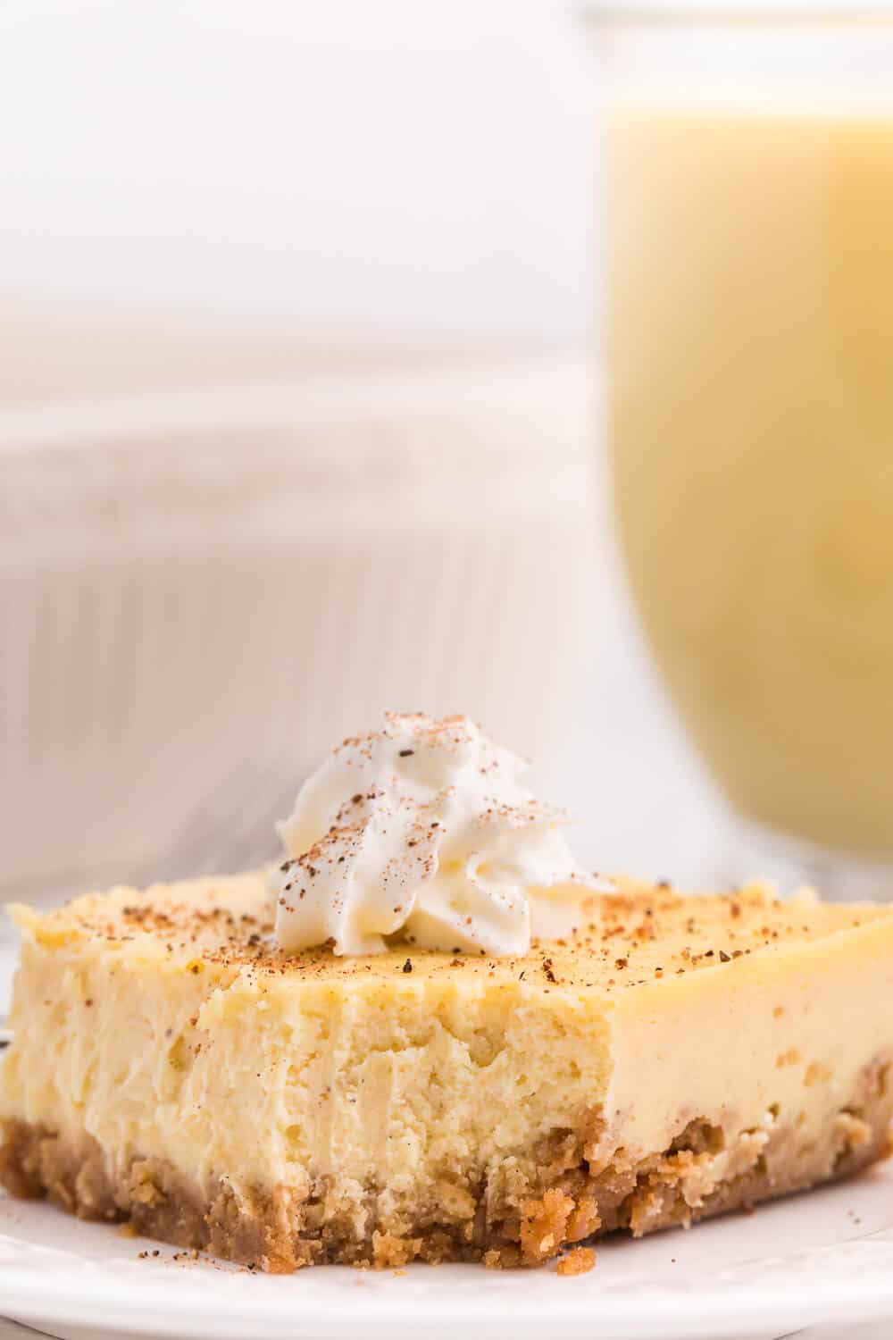 Eggnog cheesecake bar with a slice bitten off the end.
