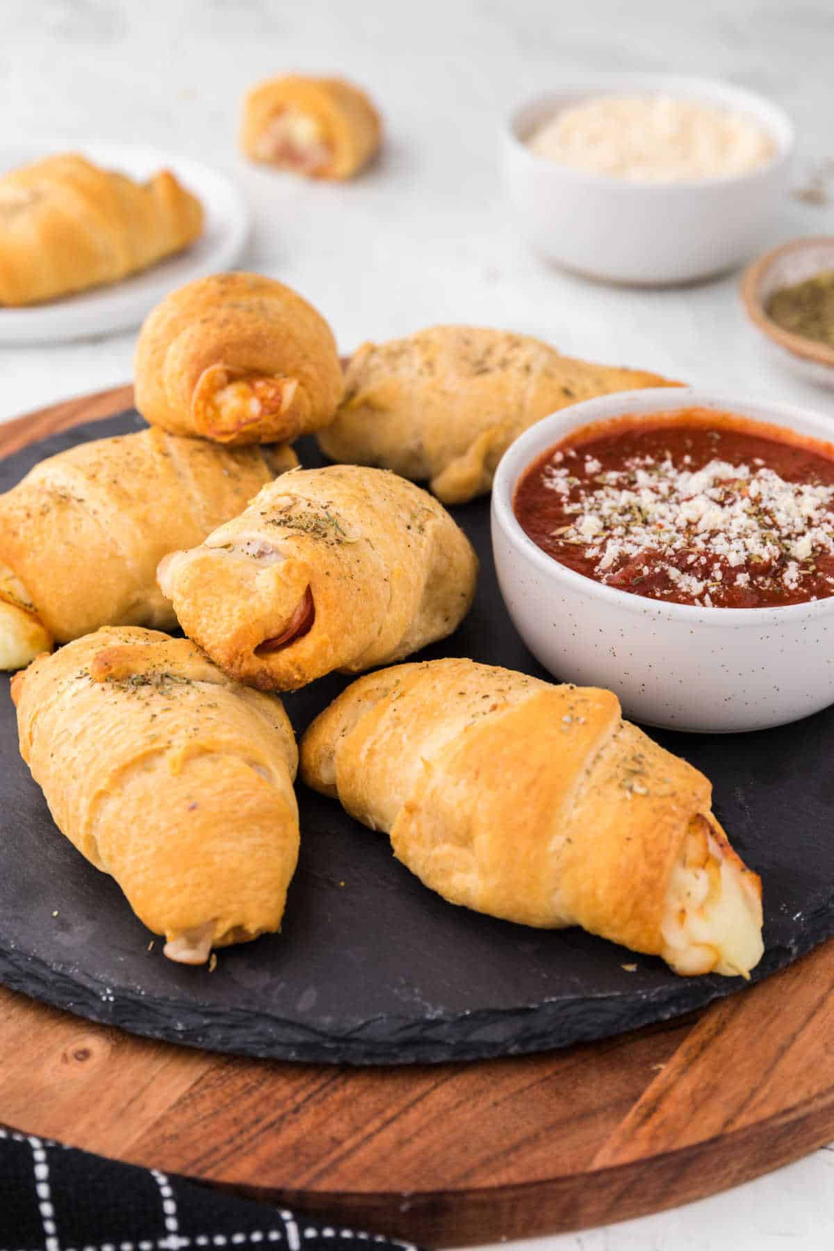 Pizza rolls on a black round slate.