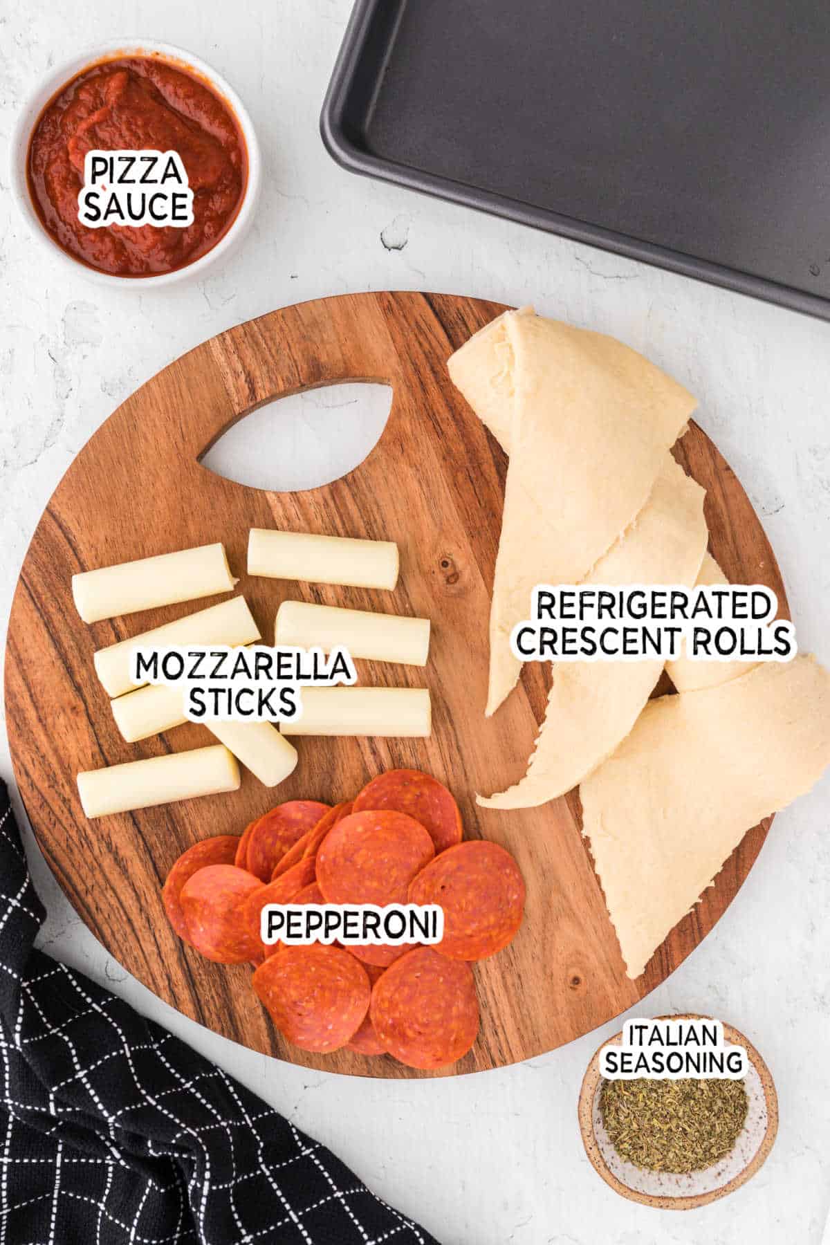 Pizza rolls ingredients on a circle wooden cutting board.