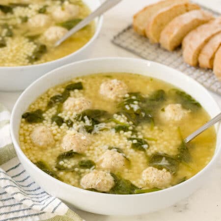 Italian meatball soup in a bowl with a spoon.