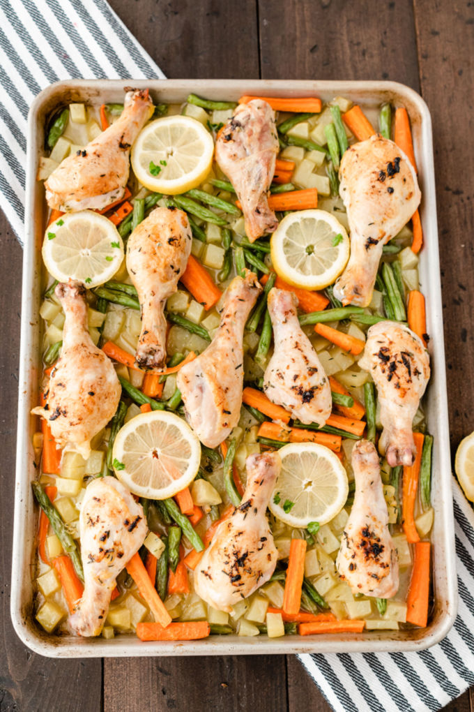 One-Pan Lemon Thyme Chicken - Tender, flavourful chicken drumsticks covered in a lemon/herb butter spread are roasted to perfection along with carrots, potatoes and green beans on one pan! You'll love how easy it is to make and clean.