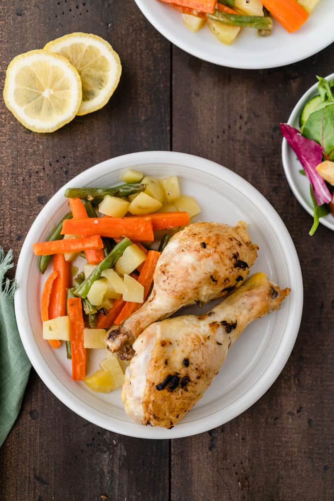 One-Pan Lemon Thyme Chicken - Tender, flavourful chicken drumsticks covered in a lemon/herb butter spread are roasted to perfection along with carrots, potatoes and green beans on one pan! You'll love how easy it is to make and clean.