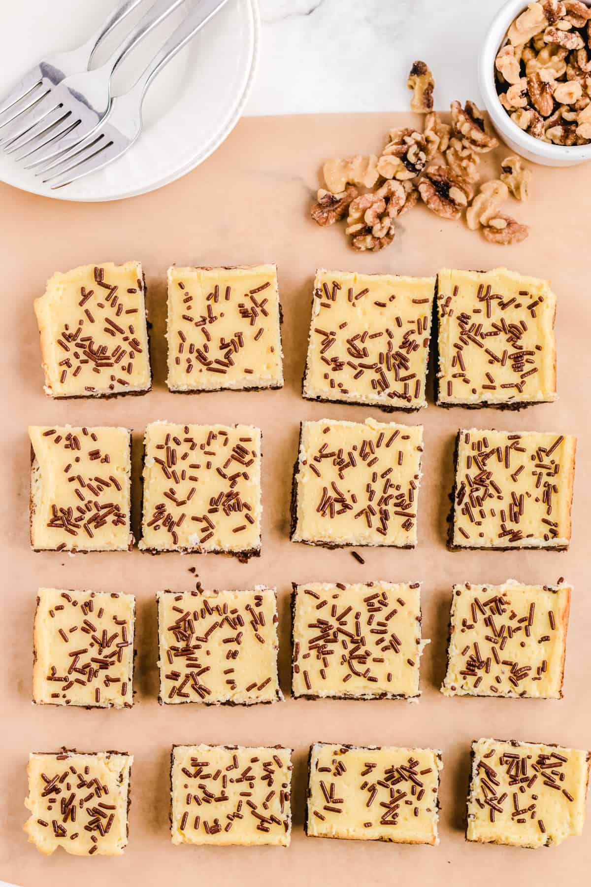 Cheesecake squares on a parchment paper.