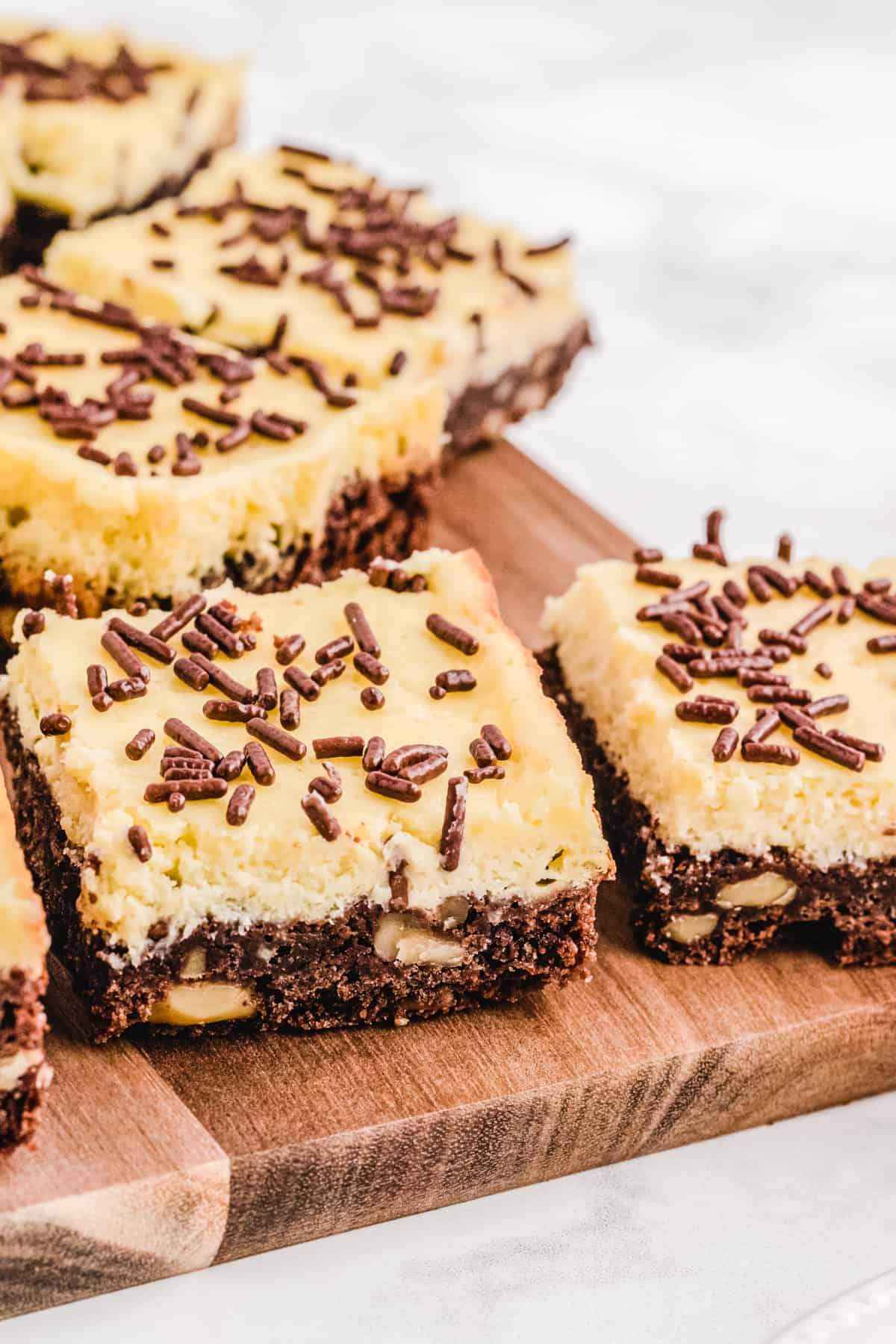 Cheesecake squares on a wooden cutting board.