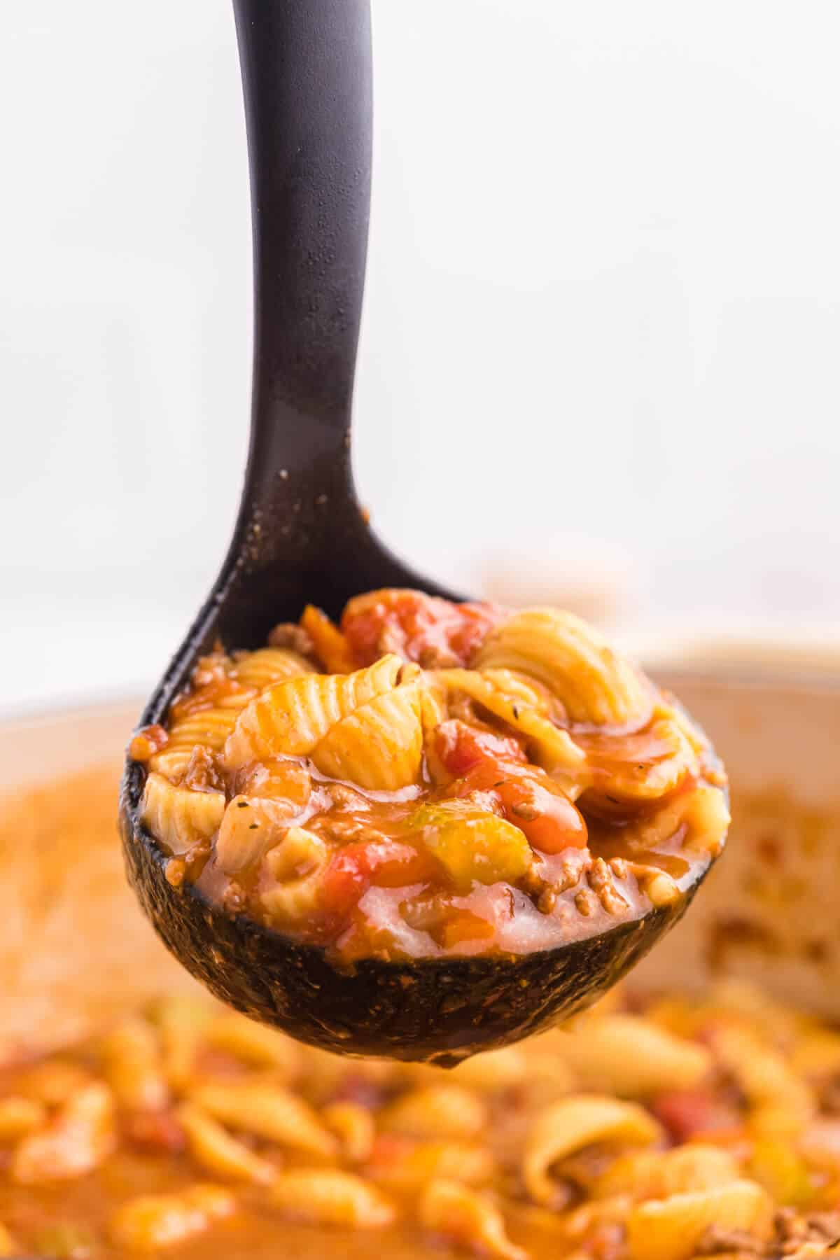 Hamburger soup in a ladle.